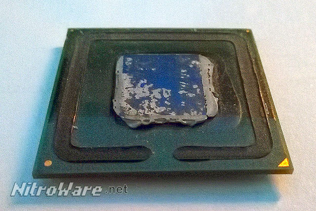 To illustrate de-lidding, we have removed the lid/heat spreader from a Pentium 4 CPU for socket 478. The black ring is the lid's adhesive and visible on the unmarked die is the thermal compound. Delidded Intel CPU